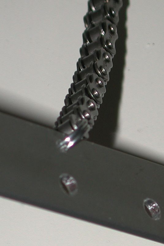 metal bar with roller chain attached, detail shot